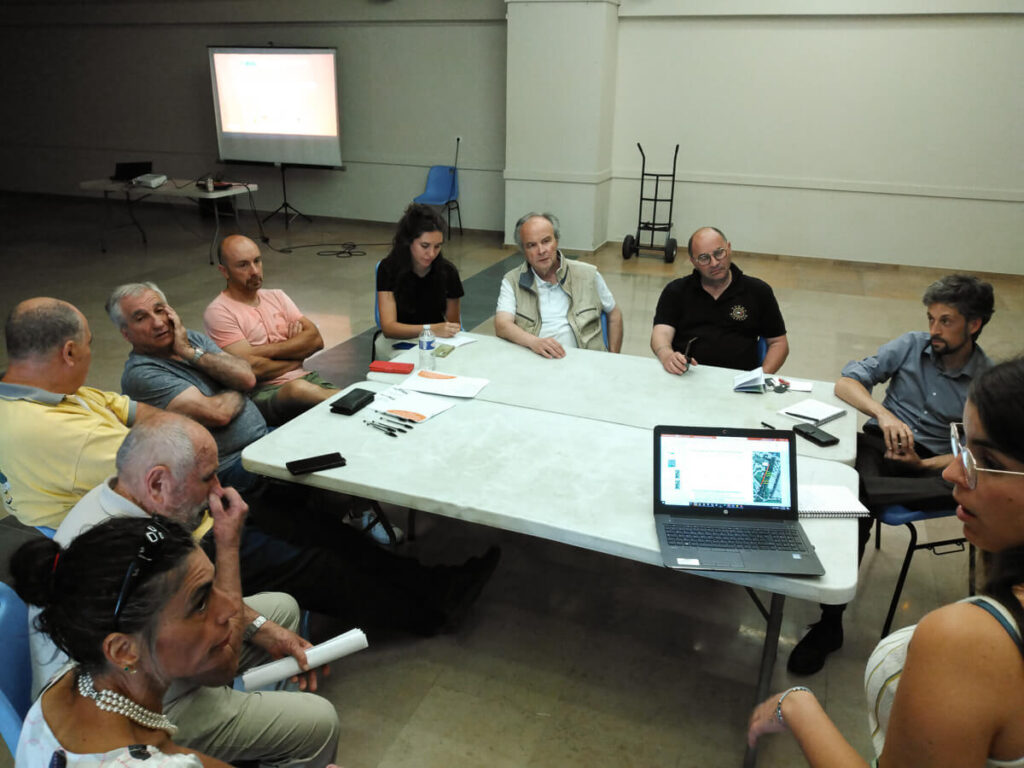 Photo des participants à l'atelier de concertation de Laragne autour d'une table dans la salle des fêtes de Laragne